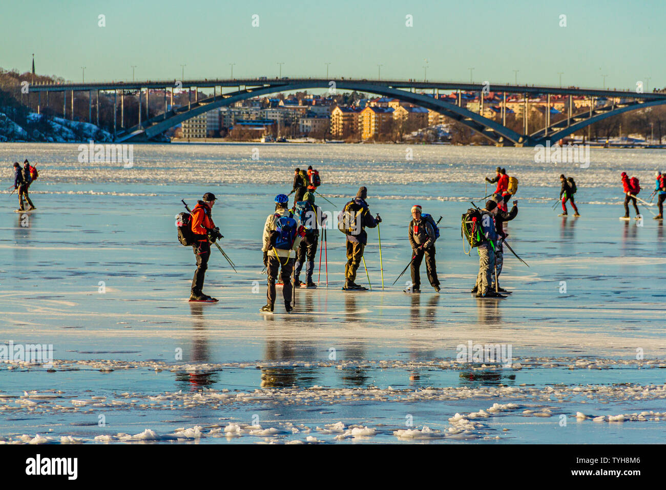 Eine Gruppe von schlittschuhläufer auf den Riddarfjärd, einer Bucht des Sees Malaren, mit dem Vasterbron West Bridge hinter sich. Stockholm, Schweden. Januar 2019. Stockfoto