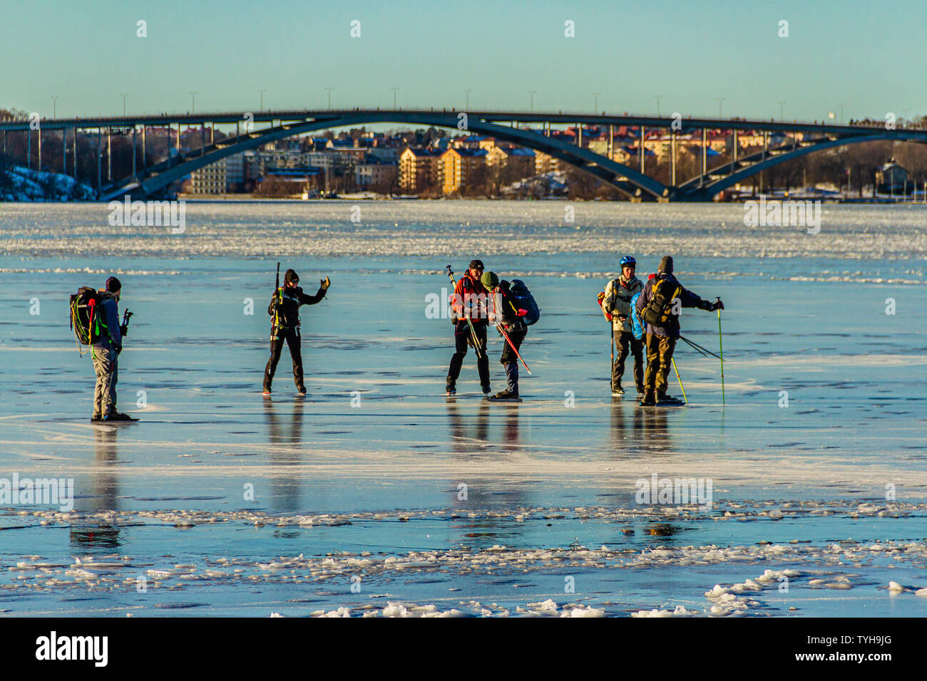 Eine Gruppe von schlittschuhläufer auf den Riddarfjärd, einer Bucht des Sees Malaren, mit dem Vasterbron West Bridge hinter sich. Stockholm, Schweden. Januar 2019. Stockfoto