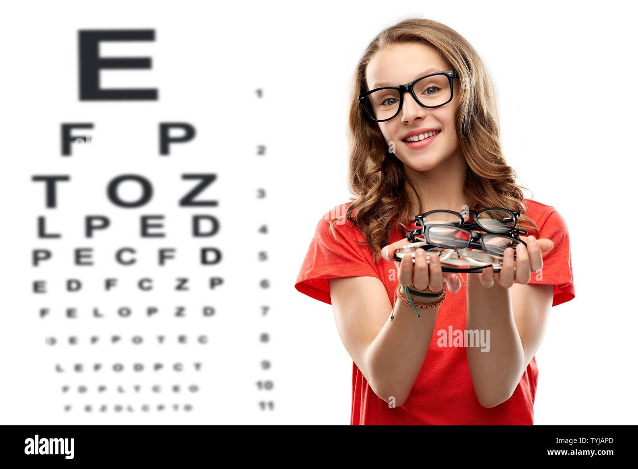 Junges Mädchen mit Brille über Auge Test Chart Stockfoto