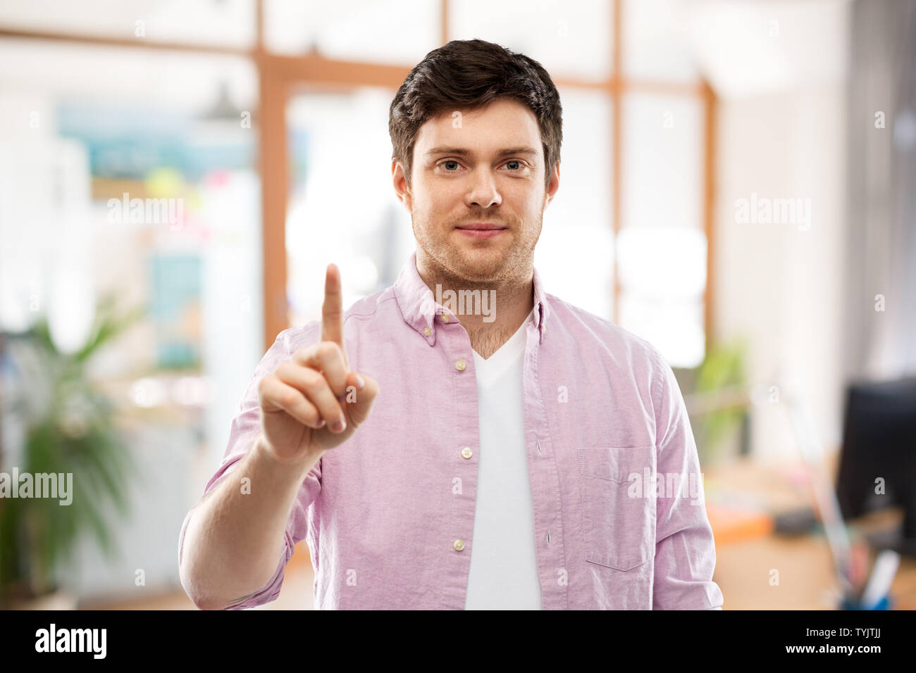 Junger Mann mit einem Finger über Amt Stockfoto