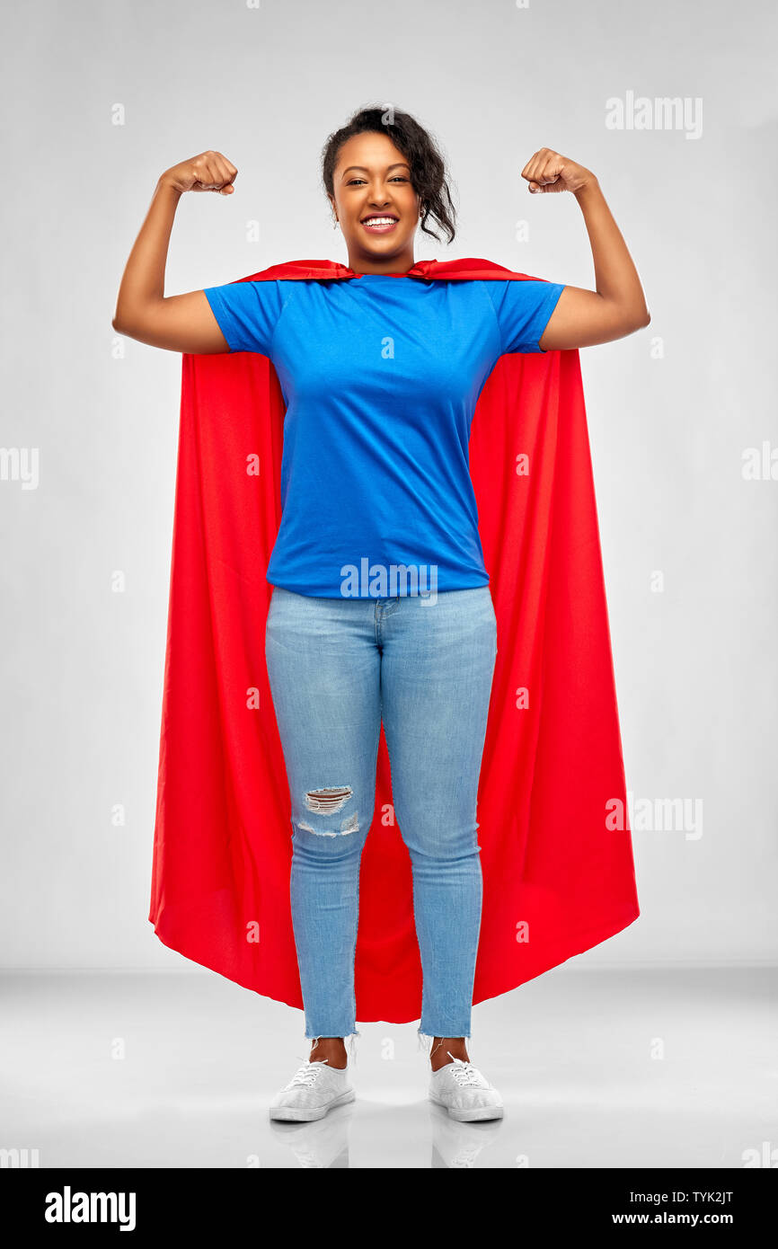 Glückliche afroamerikanische Frau in Superhelden red Cape Stockfoto