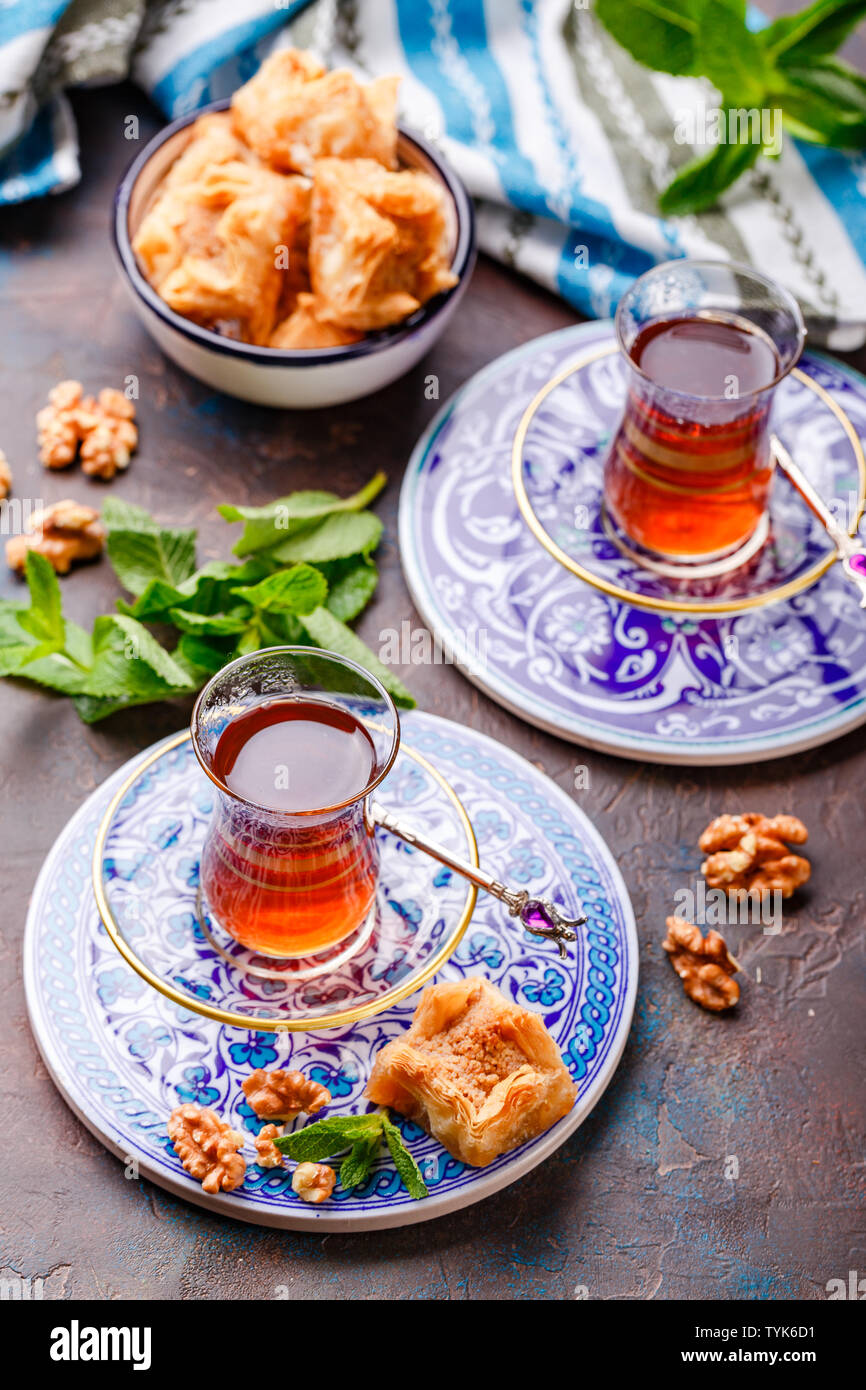 Im Nahen und Mittleren Osten oder arabischen Tee mit Minze in einem traditionellen Glas Schale und Türkische Süßigkeit Baklava. Ramadan Kareem. Eid Mubarak. Islamische Feiertage decorat Stockfoto