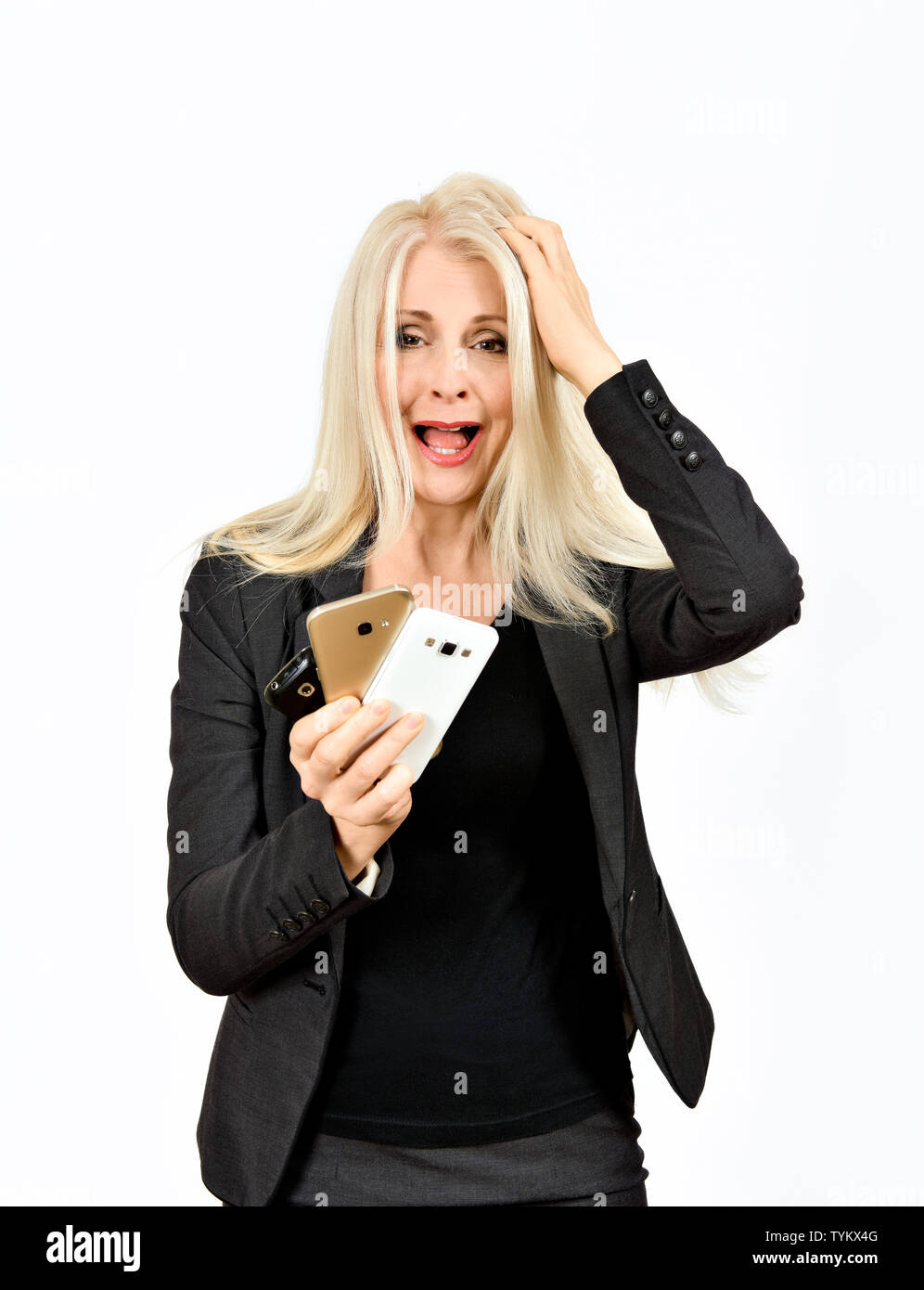 Business Frauen in Verzweiflung mit der Hand auf den Kopf und halten drei Mobiltelefone nicht wissend, welche zuerst beantworten Stockfoto