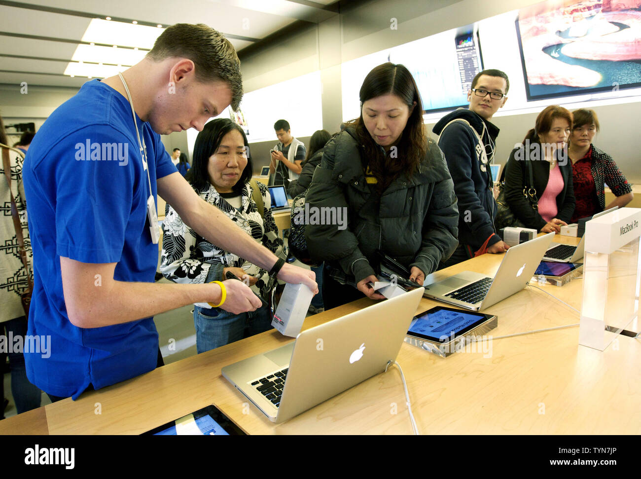 Ein Mitarbeiter (L) hilft seinen Kunden mit dem neuen iPhone 5, die zum Verkauf an der Apple Flagship Store in der Fifth Avenue haben am 21. September ging, 2012 in New York City. Die neue Version von Apples Smartphone verfügt über einen schlankeren Design, größeren Bildschirm und ein schnelleres Surfen beschleunigen. UPI/Monika Graff Stockfoto