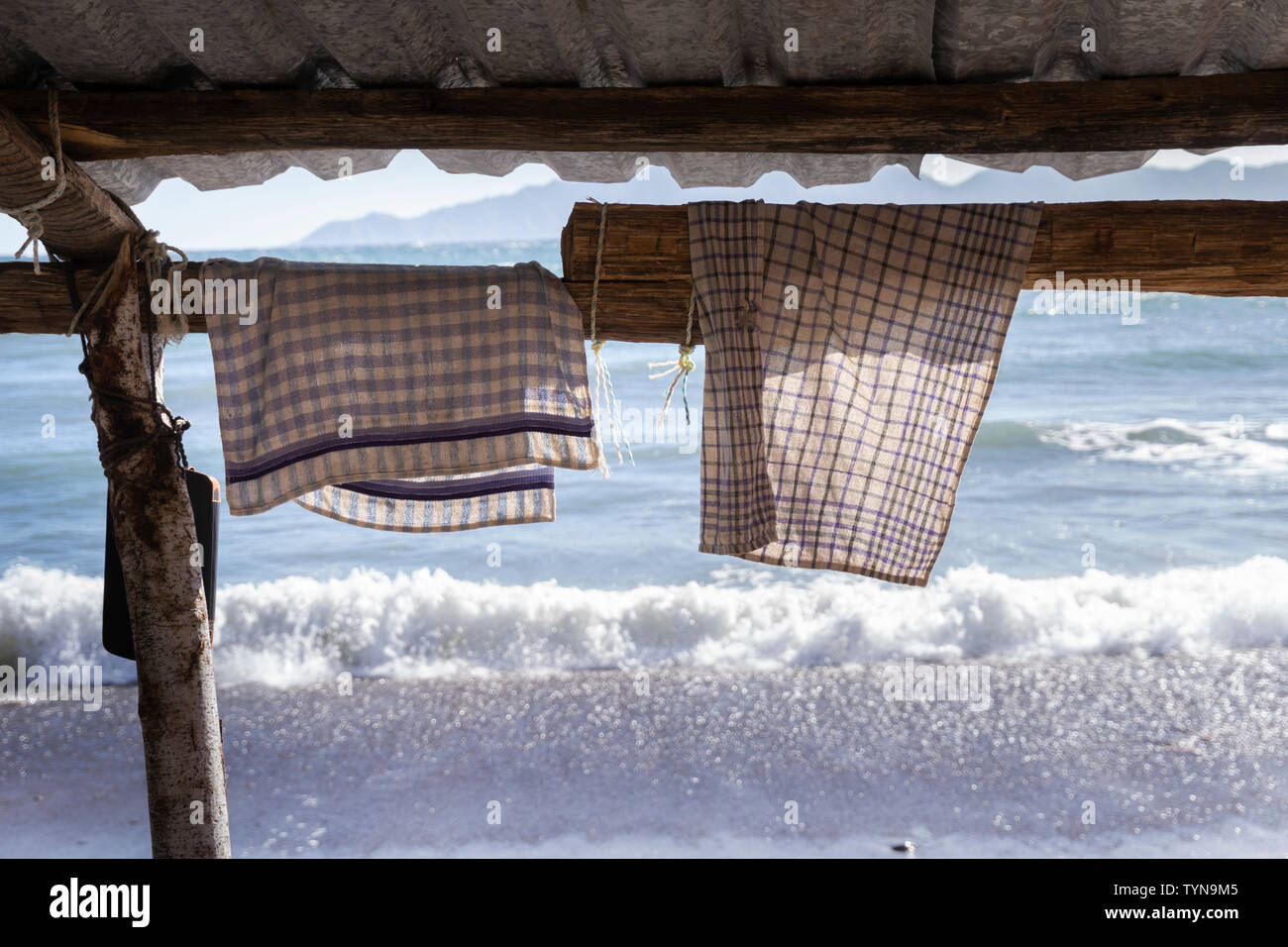 Geschirrhandtuch hängt für den Versuch, auf einem hölzernen Gerüst am Strand Stockfoto