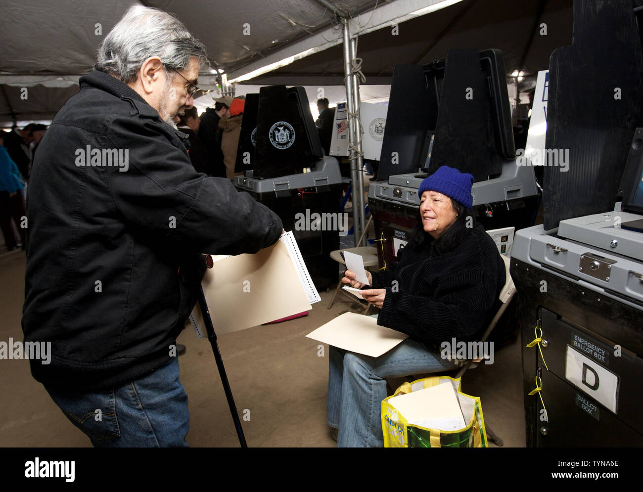 Leslie Masiowicz, eine Wahl Sekretärin, hilft bei der Wähler bei einem make-shift Polling site, die Beleuchtung fehlt und ist in einem Zelt an den Rockaway Park im Stadtteil Queens am 6. November 2012 in New York City. Vielen Wahllokalen in der gesamten Küstenregion Nachbarschaften wurden durch Hurrikan Sandy beschädigt. UPI/Monika Graff Stockfoto