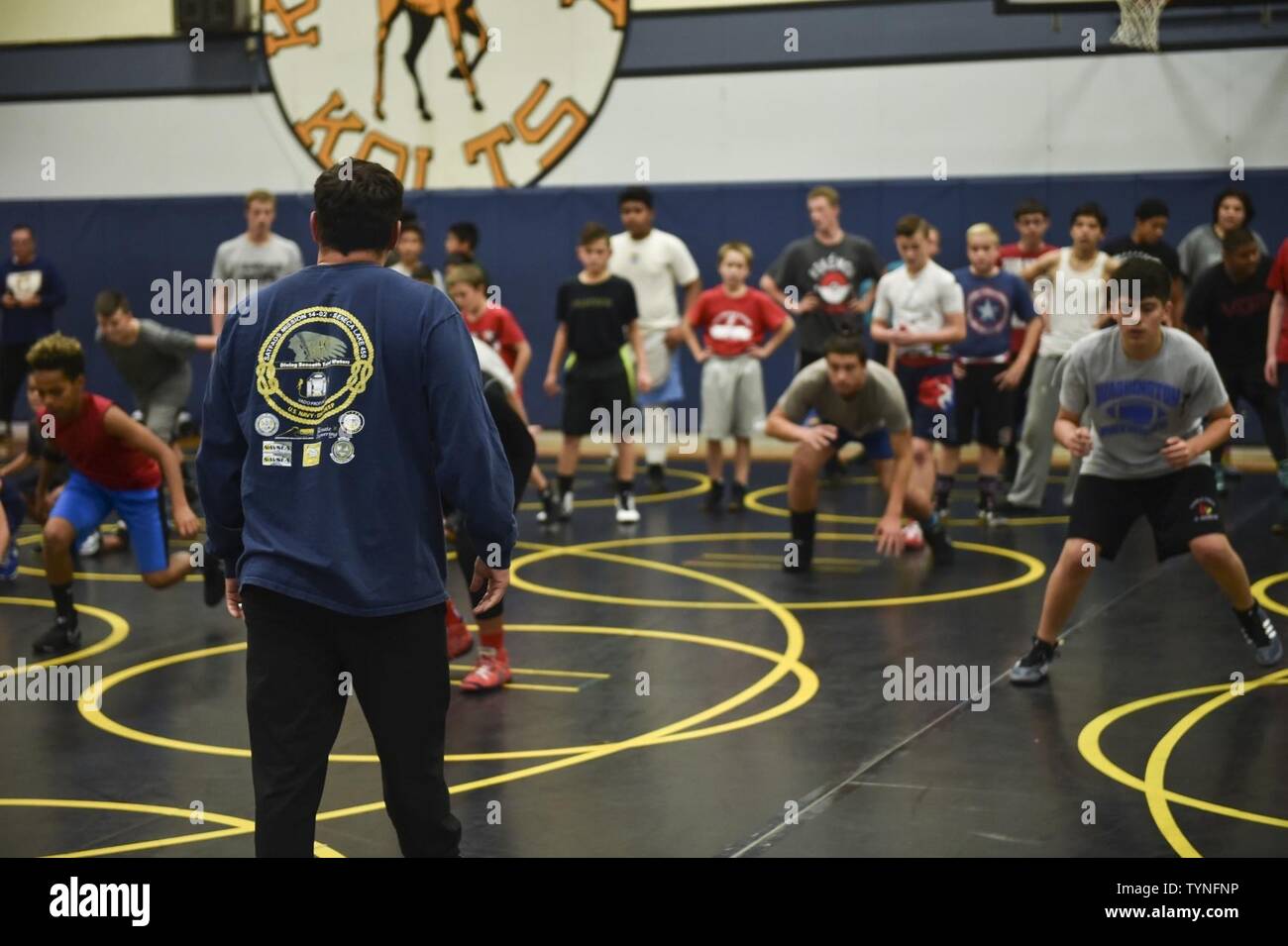 TACOMA, Washington (Nov. 18, 2016) All-Navy Wrestling Head Coach, Chief Petty Officer Alejandro Delapeña, stationiert mit Naval Undersea Warfare Center, Division Keyport, leitet das Warm-up extercises beim Führen einen Rückgang kick-off wrestling Klinik am Keithley Middle School. Die Klinik, für jugendliche Sportler, wurde von Kyle Foster, athletischen Direktor der Schule, und seine Wrestling Club Team Werfen'em. Stockfoto