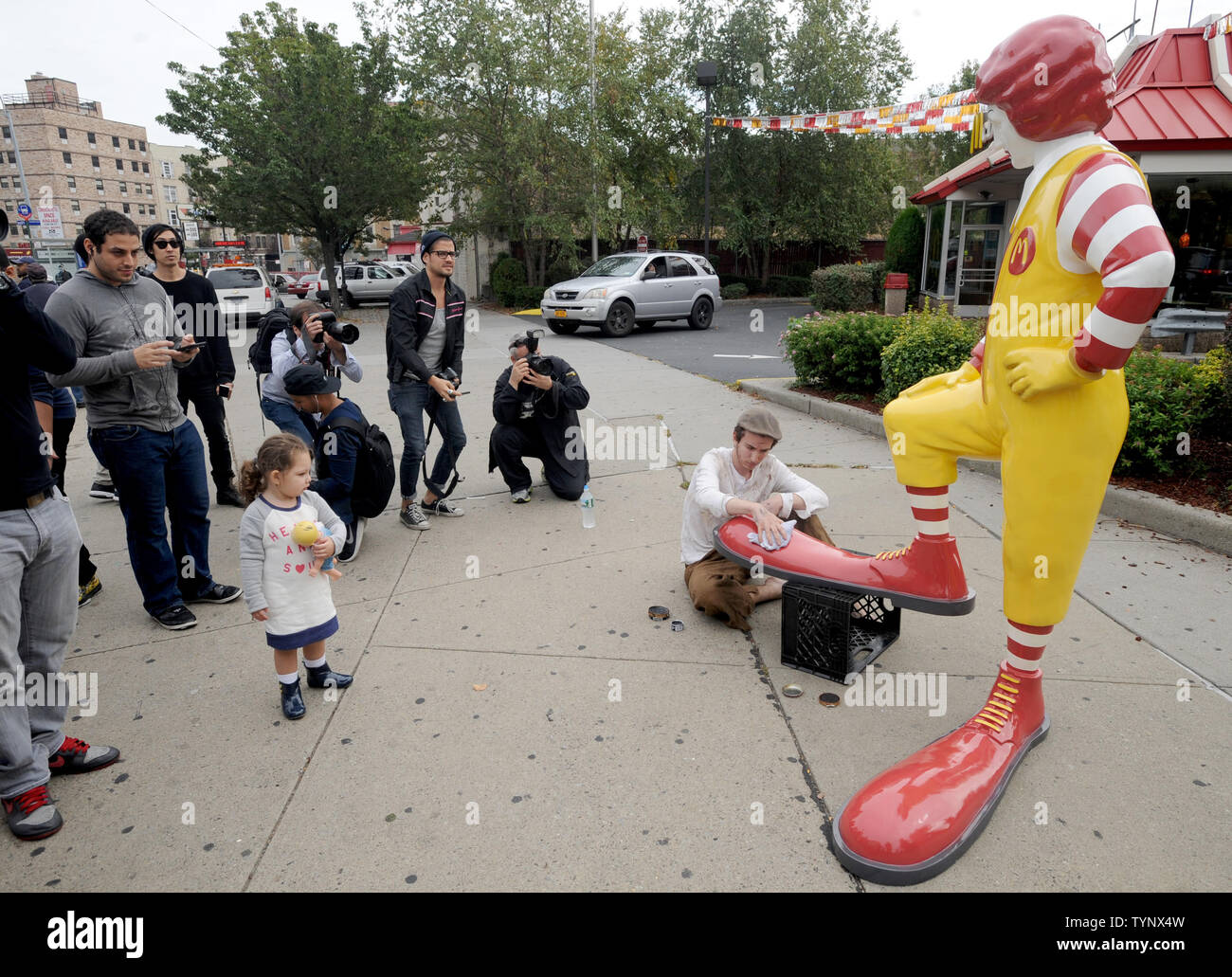 Ein gfk Nachbau des Ronald McDonald seine Schuhe in glänzte durch eine  echte live Junge wird der Bürgersteig außerhalb einer anderen McDonalds  Besuch jeden Mittag für die nächste Woche als ein Werk