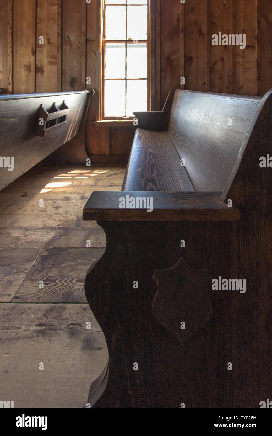Leere Kirche Pew in vertikaler Ausrichtung. Altmodische Holz Kirche pew in kleinen ländlichen Amerikanischen Kirche. Stockfoto
