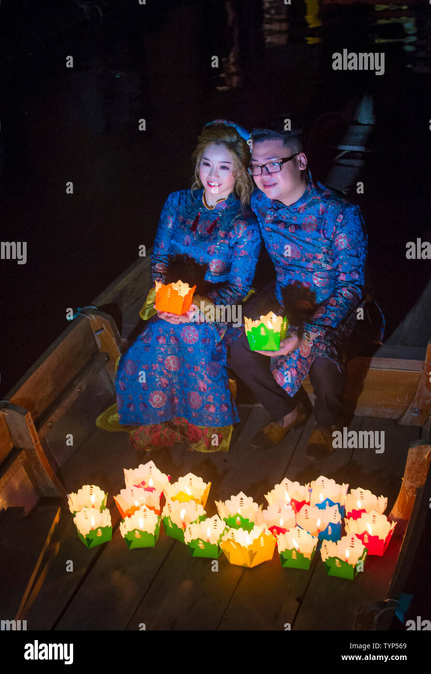 Vietnamesische paar Laternen Holding vor Ihnen droping in den Fluss in Hoi An, Vietnam während der Hoi An Vollmond Laternenfest Stockfoto