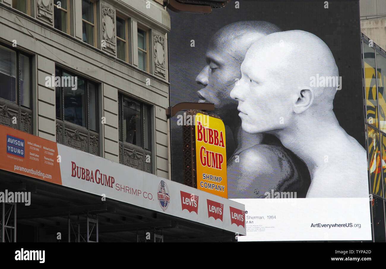 Menschen gehen durch die Werke der Kunst, wenn Kunst überall geht auf Anzeige in der Times Square in New York City am 4. August 2014. Bilder von großer amerikanischer Kunst wird angezeigt als Teil der "Die grösste Kunst erscheinen überhaupt konzipiert werden." Die 58 Kunstwerke, umfassen die Kunst überall uns Kampagne wird von Küste-zu-Küste im gesamten August sein. UPI/John angelillo Stockfoto