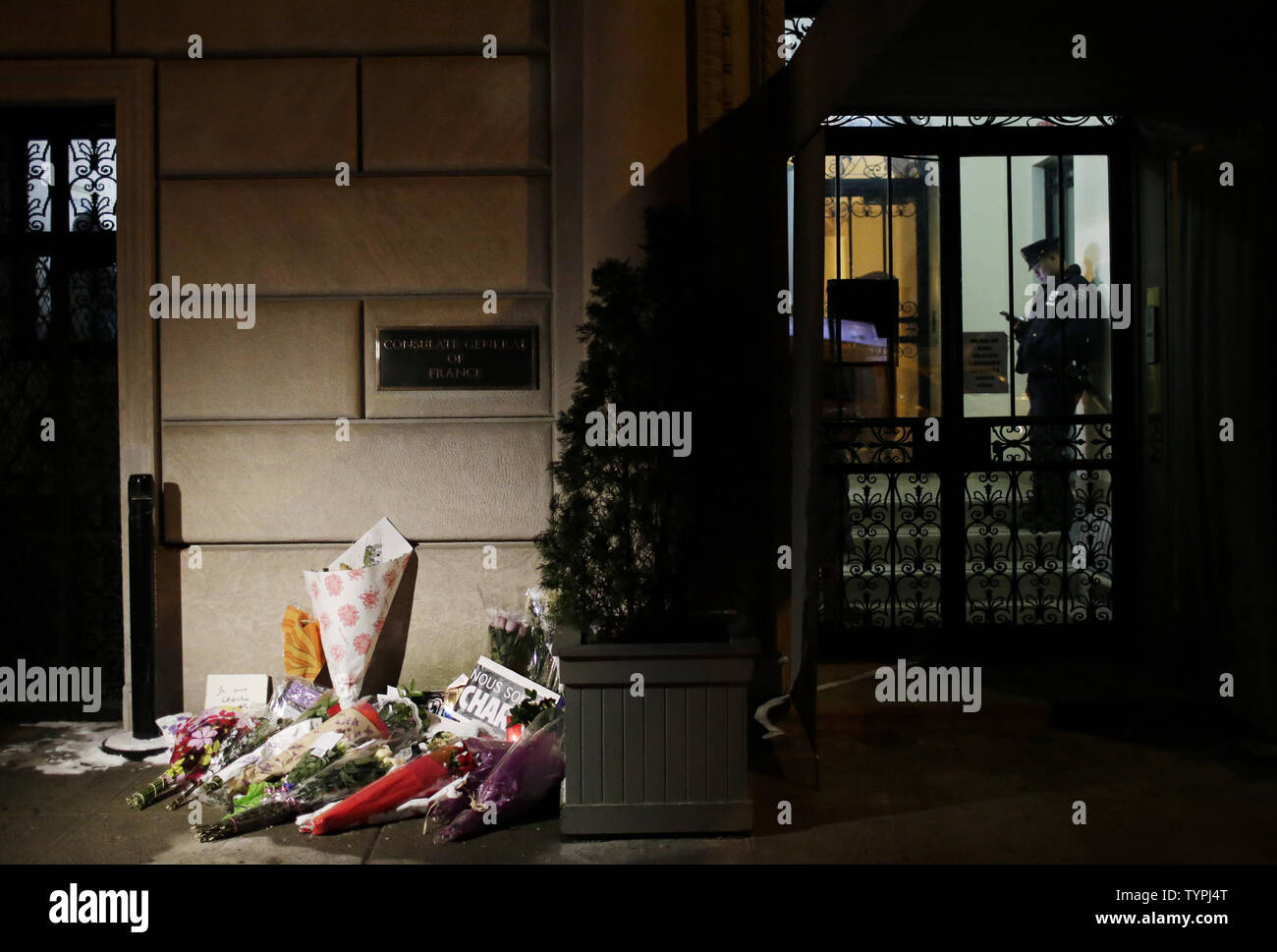 Eine NYPD Polizisten wacht im Französischen Konsulat auf der 5th Avenue in New York City am 9. Januar 2015. 12 Menschen wurden am 7. Januar getötet, darunter zwei Polizisten, als zwei bewaffnete Männer das Feuer eröffnete in den Büros der französischen Satirezeitschrift Charlie Hebdo veröffentlicht. Ein paar dramatische Überfälle Freitag in Frankreich führte zu der Ermordung von drei Terroristen. In der tödlichen Schießen von einer Polizistin und vier Geiseln vermutet, die anderen beiden an dem Massaker in den Büros von Charlie Hebdo Zeitschrift. Foto von John angelillo/UPI Stockfoto