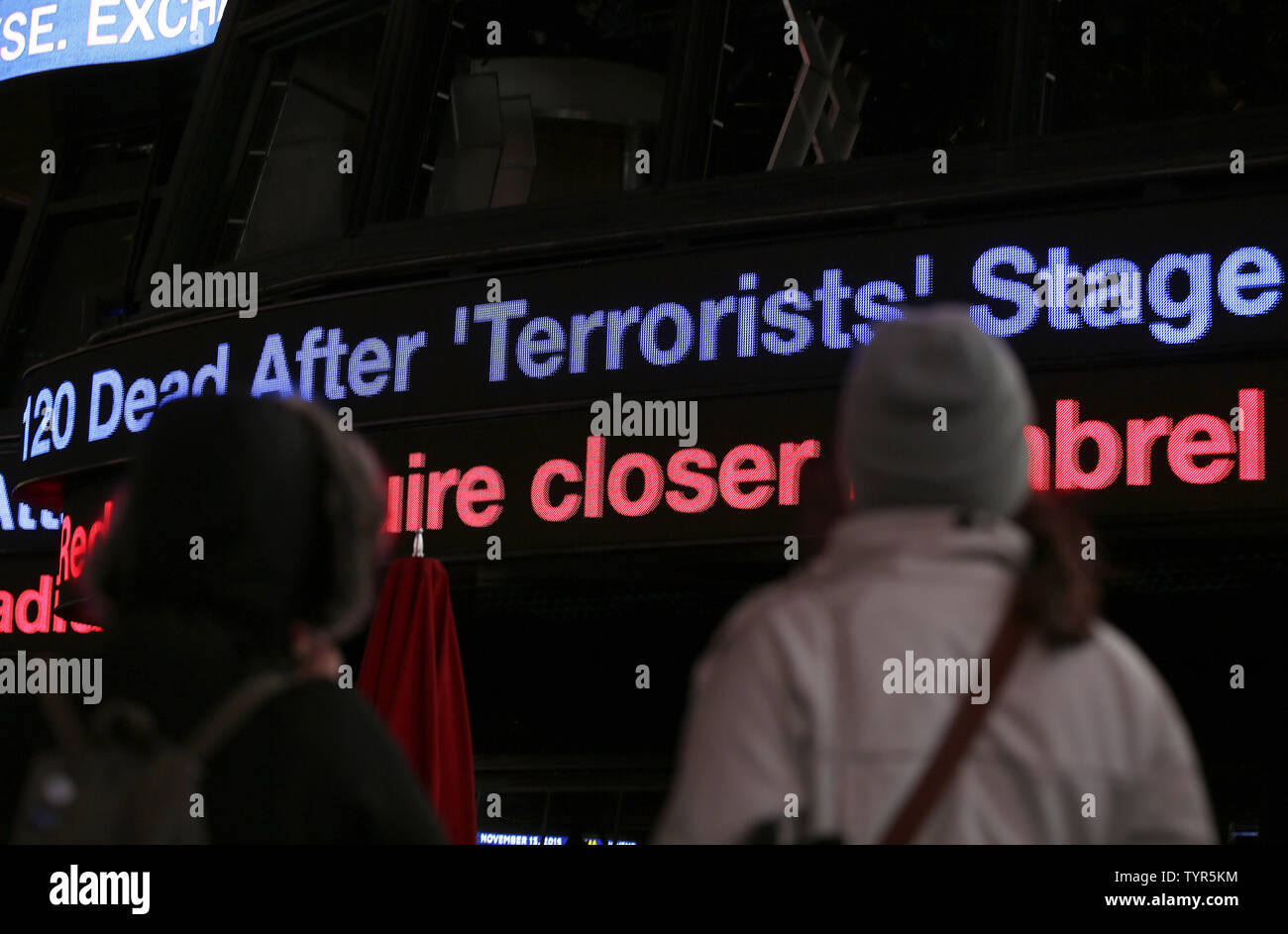 Menschen stehen im Times Square als Nachrichten von der Pariser Terroranschläge auf Plakatwänden und Ticker am 13. November zu sehen, 2015 in New York City. Insgesamt wurden sechs Standorten in und außerhalb der Hauptstadt angegriffen. Mindestens 153 Menschen wurden in den Paris, Saint-Denis shootings und Bombardierungen getötet. Foto von John angelillo/UPI Stockfoto