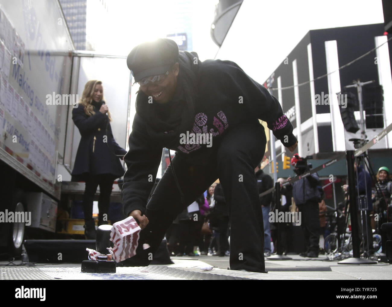 Eine Frau zerschlägt ihr Wecker, wenn Leute in Times Square zu vernichten, sammeln und schlechte Erinnerungen von 2015 an der 9. jährlichen Good Riddance Tag in New York City zu zerstören am 28. Dezember 2015. Ein Shred-it mobile Zerkleinerung Lkw war an Hand zu verwerfen und lustige, ausgefallene zerstören und schmerzliche Erinnerungen an das vergangene Jahr, so dass die Teilnehmer einen Schritt näher zu einem Neuanfang im Jahr 2016 zu verschieben. Foto von John angelillo/UPI Stockfoto