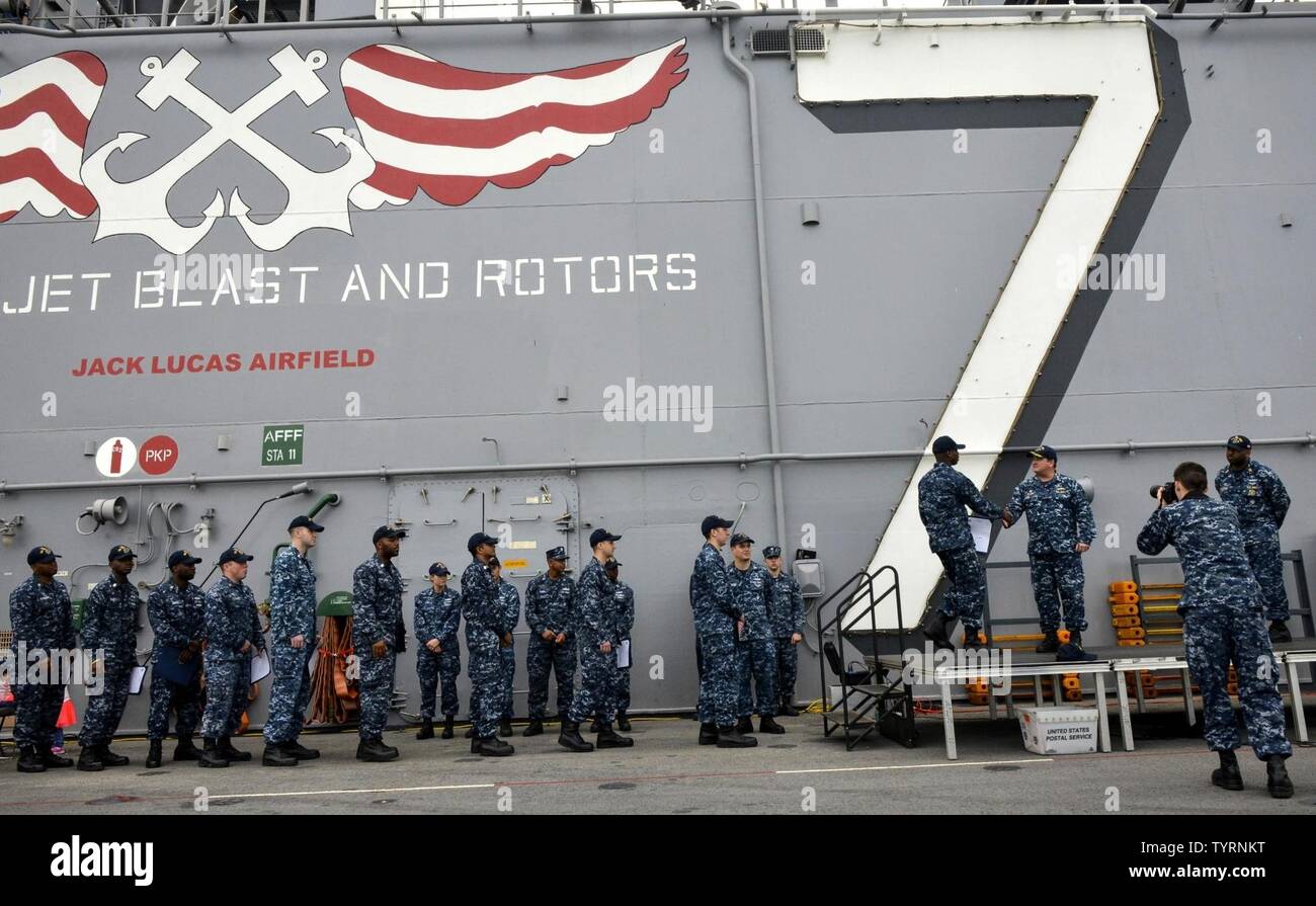 MAYPORT, Fla (Nov. 23, 2016) - Neu - gefördert Matrosen bereiten Hände mit Kapitän James Midkiff zu schütteln, kommandierender Offizier der Amphibisches Schiff USS Iwo Jima (LHD7), während einer Zeremonie am frocking Flight Deck des Schiffes. Iwo Jima vor Kurzem kehrte zu ihrem Heimathafen in Veteranen Woche nach New York City 2016 Teilnehmenden der Service für alle unsere Nation Veteranen zu ehren. Stockfoto