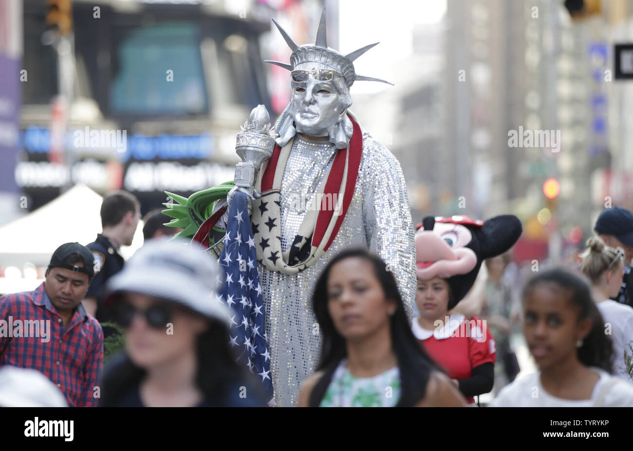 Ein Mann gekleidet wie die Freiheitsstatue Spaziergänge unter Fußgänger im Times Square am Vorabend der 4. Juli Unabhängigkeitstag am 3. Juli 2017 in New York City. Foto von John angelillo/UPI Stockfoto