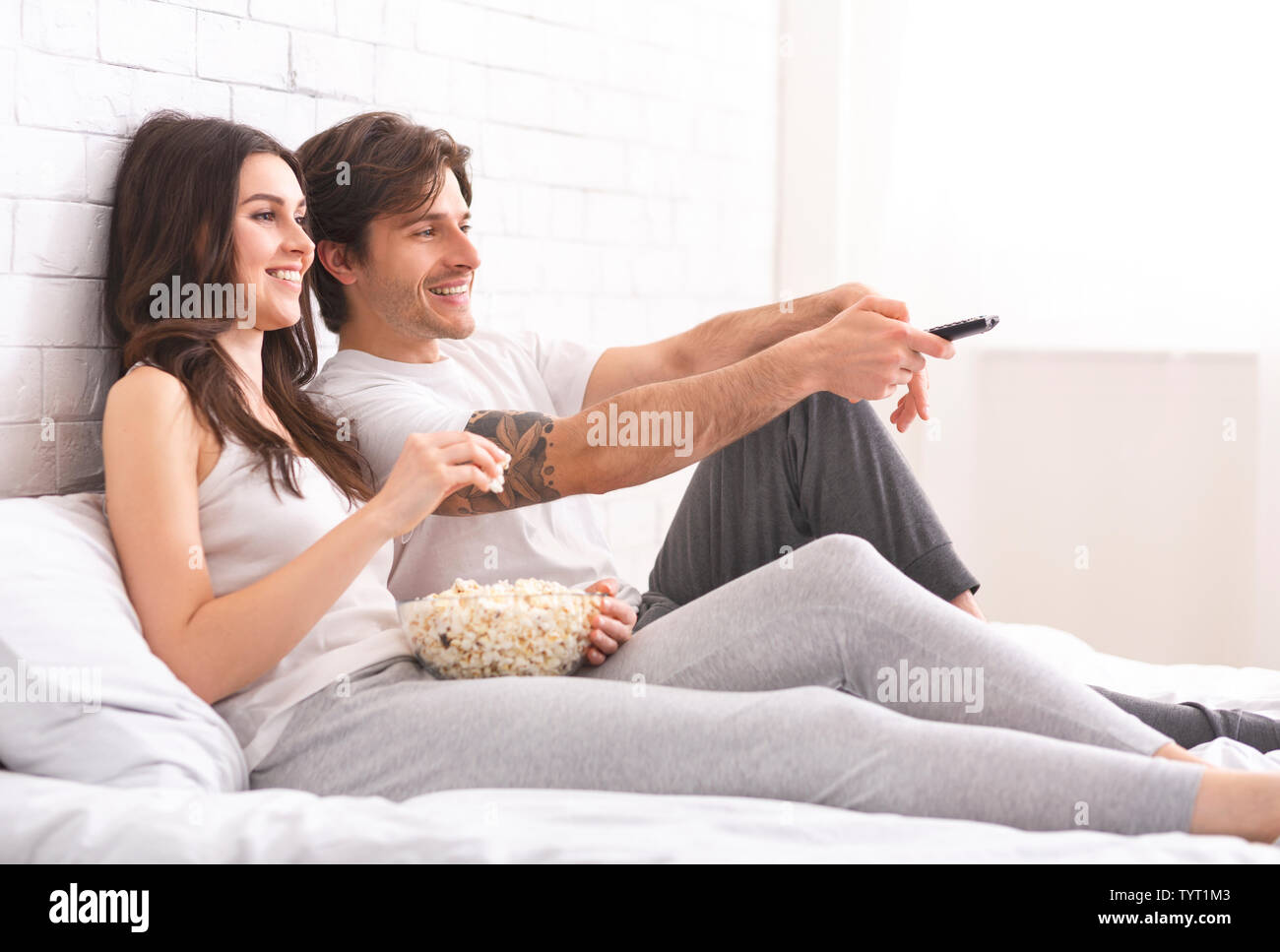 Mann und Frau in der Liebe ansehen Film mit Popcorn im Bett Stockfotografie  - Alamy