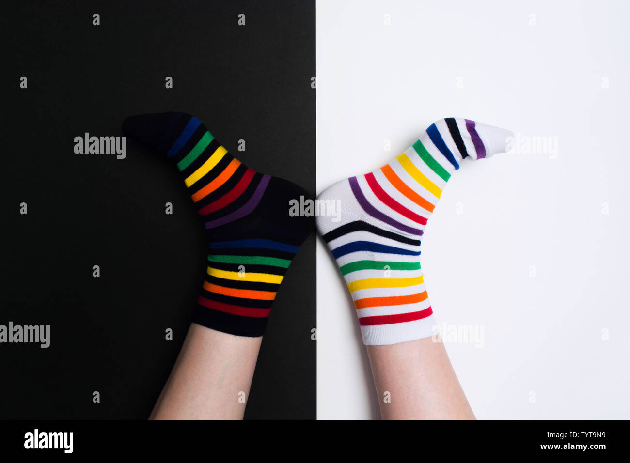 Lustige Beine mit weißen und schwarzen neue saubere Farbenfrohe Textilien Socken gestreift. Mode Accessoires für Füße mit negativen Hintergrund mit kopieren. Flach Stockfoto