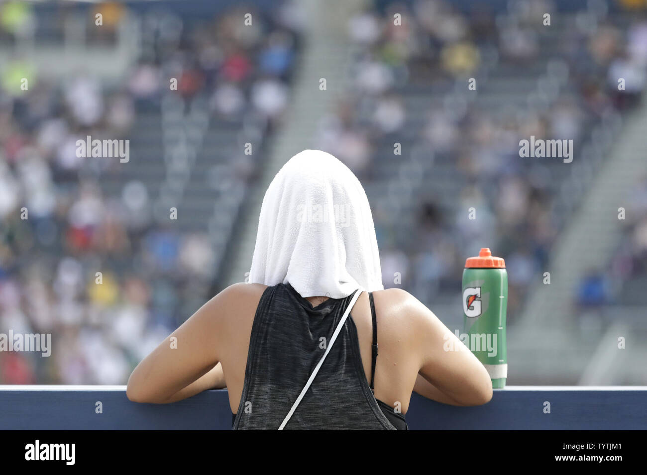 Eine Frau trägt ein nasses Handtuch auf dem Kopf, von dem heißen und feuchten Wetter zu kühlen, während Caroline Garcia von Frankreich spielen Johanna Konta des Vereinigten Königreichs in der ersten Runde auf der Tribüne an der 2018 US Open Tennis Championships am USTA Billie Jean King National Tennis Center in New York City am 28. August 2018. Foto von John angelillo/UPI Stockfoto