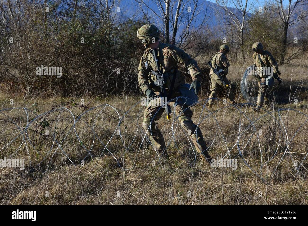 Us-Armee Fallschirmjäger zu 173Rd Airborne Brigade, BSB B Co zugeordnet, ordnet concertina Draht um den Befehl post Bereich der operativen heasquarters zu gewährleisten, Maniago Training Area in Aviano, Italien, November 29, 2016. Sie werden die BANDIT FTX WOLVERINE STREIK 16 Ausbildung mit Unterstützung der einsetzbaren Mess System Europa oder DISE leiten. Stockfoto