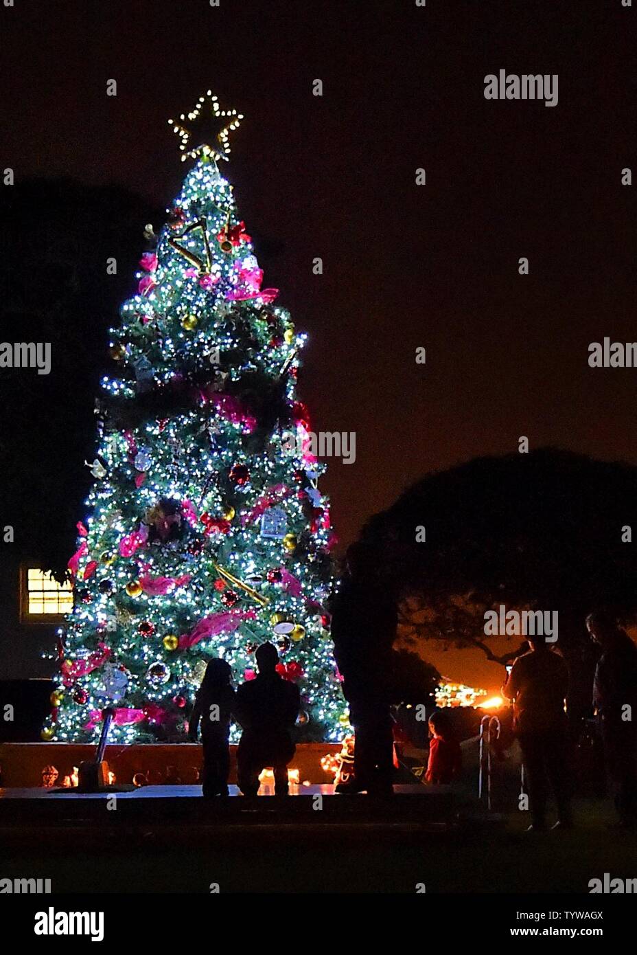 Bewundern Sie den Baum Stunden später nach 61 Air Base Group Commander, Col Charles Roberts, zusammen mit einigen seiner kleinen Helfer schlug den Schalter, um den Weihnachtsbaum zu Licht, in der Nähe der Parade am Fort MacArthur, San Pedro, Calif, Nov. 30, 2016. Familie, Freunde und Bewohner wurden dann zu essen, Spielzeug, Kunsthandwerk und ein Besuch mit Santa in der Community Center behandelt. Stockfoto