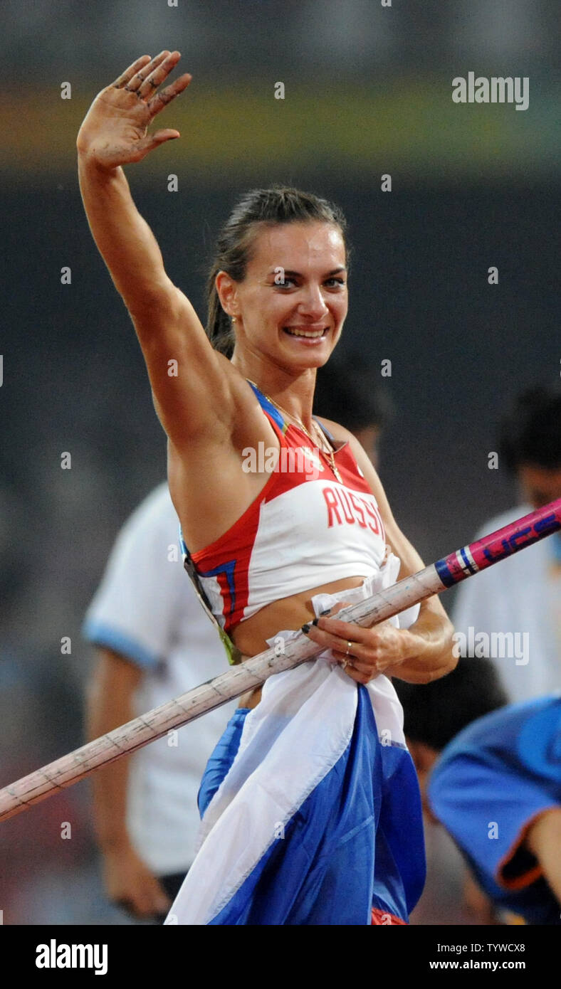 Russlands Elena Isinbaeva Wellen, als sie ihre Pole und Flagge trägt, nachdem Sie die Bar auf 5,05 m (16 Fuß, 7 Zoll) das Gold zu gewinnen gelöscht und einen neuen Weltrekord im Stabhochsprung der Damen auf dem "Bird's Nest" National Stadium bei den Olympischen Sommerspielen in Peking am 18. August 2008. (UPI Foto/Pat Benic) Stockfoto