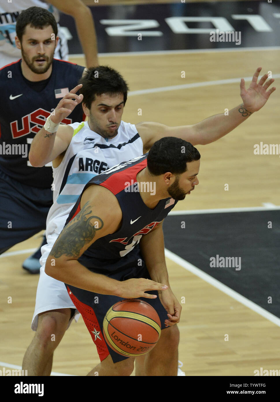 Argentiniens Facundo Campazzo (C) wird zwischen die Deron Williams der Vereinigten Staaten fahren während der USA-Argentinien Men's Basketball vorläufige Konkurrenz an den olympischen Sommerspielen 2012, 6. August 2012, in London, England zum Korb und Kevin Liebe gefangen. UPI/Mike Theiler Stockfoto