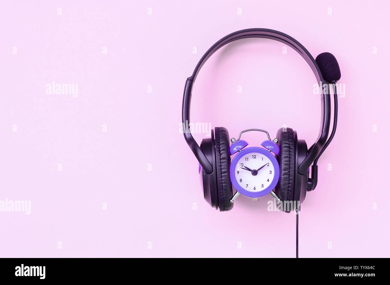 Retro Wecker mit schwarz Kopfhörer auf rosa Hintergrund. Konzept der Zeit  Musik hören Stockfotografie - Alamy