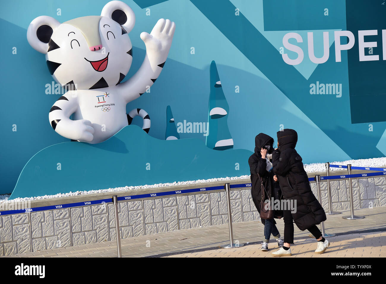 Zuschauer schützen ihre Gesichter Durchbrennen von Ablagerungen, wie sie der Olympic Park, nachdem starke Winde durch die Region, die die Pyeongchang 2018 Winter Olympics fegte, in Tainan, Südkorea, am 14. Februar 2018 verlassen. Foto von Richard Ellis/UPI Stockfoto