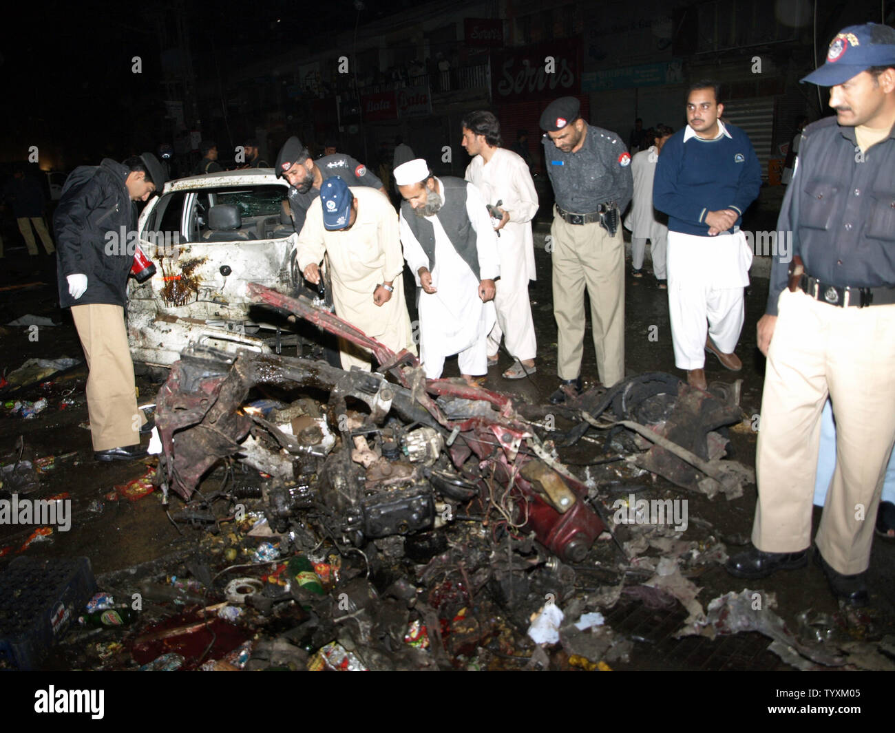 Die pakistanischen Polizisten inspizieren ein Fahrzeug von einem Auto Bombenanschlag in Charsadda, Pakistan am 10. November 2009 zerstört. Die Autobombe explodierte vor einem überfüllten Markt im Nordwesten Pakistans tötet 24 Menschen in dem jüngsten Angriff. UPI/Sajjad Ali Qureshi. Stockfoto