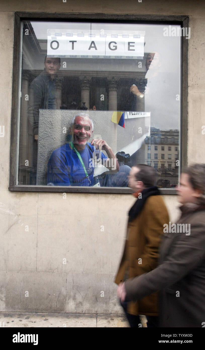 Agence France Presse Mitarbeiter post ein riesiges Bild von Ihrer Kollegin, peruanische Fotograf Jaime Razuri auf einem Fenster Ihres Büros Hauptsitz in Paris, 05. Januar 2006. Es gab immer noch kein Wort über den Verbleib oder der Gesundheitszustand von Razuri, die aus einem Herzen Zustand leidet - vier Tage nachdem er in Gaza entführt, ohne Angabe, wer hinter der Entführung. (UPI Foto/Eco Clement) Stockfoto