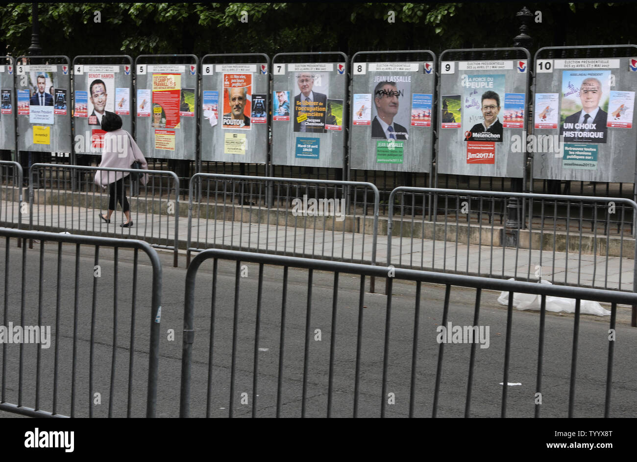 Ein Bewohner an einer Reihe von Plakaten der Präsidentschaftswahlen Kämpfer in Paris am 23. April 2017. Die Abstimmung ist in der ersten Runde der französischen Präsidentschaftswahl eine unvorhersehbare, deren Ausgang von entscheidender Bedeutung für die Zukunft einer tief gespaltenen Land und eine nervöse Europäische Union nachweisen konnte. Foto von Maya Vidon-White/UPI Stockfoto