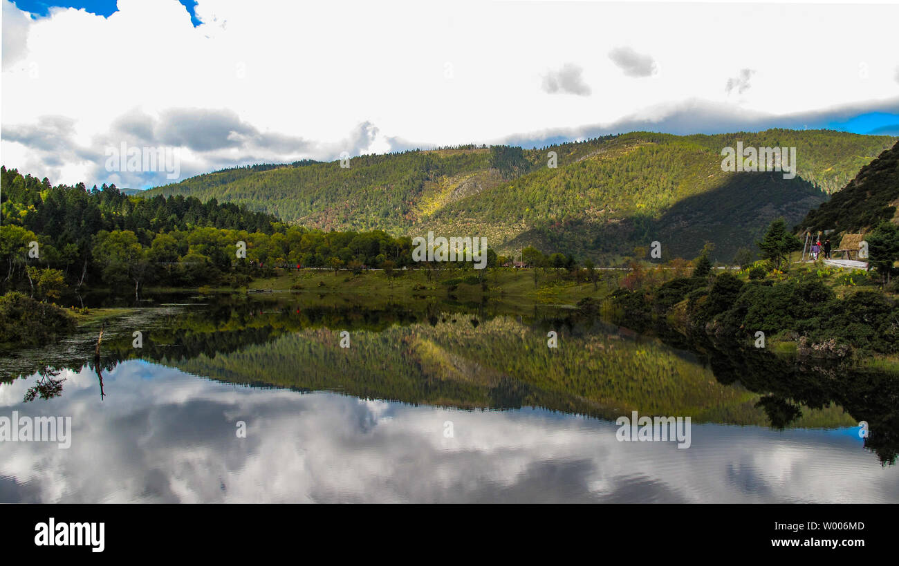 Green mountain auf einem weißen wolkigen Tag mit einem klaren Reflexion in den See. Stockfoto