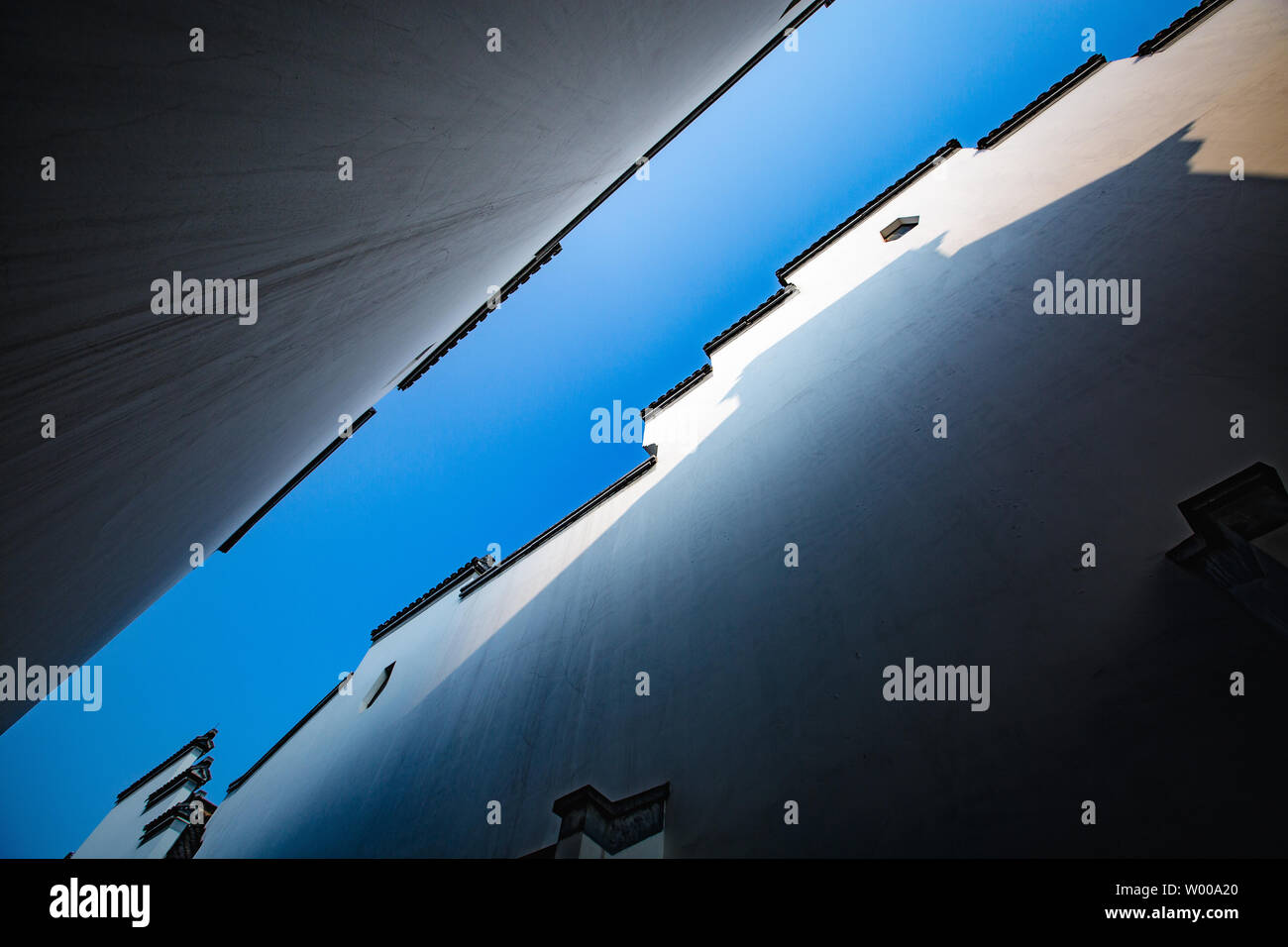 Die rosa Wand Daimatou Stadt stellt den typischen Stil von Hui Architektur, die feudale Konservative architektonische Muster ist der Marke mit dem Aufdruck der Gestaltung der traditionellen chinesischen Architektur, Licht und Schatten Projektion auf der gegenüberliegenden Wand fügt das Interesse des Bildes und den blauen Himmel und weiße Wand mit minimalistischem Stil kombiniert ist eine unverzichtbare visuelle Element des Bildes. Stockfoto