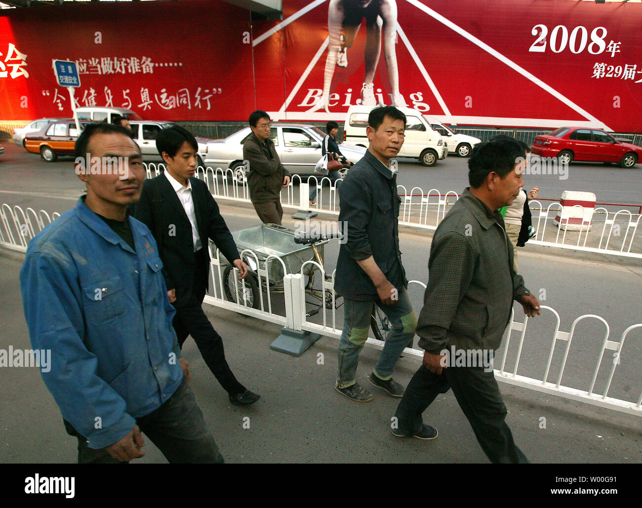 Chinesische Fußgänger Spaziergang entlang einer Straße vorbei an einem riesigen Olympischen billboard Förderung Ticketverkauf im Zentrum von Peking, China am 05 Mai, 2997. (UPI Foto/Stephen Rasierer) Stockfoto