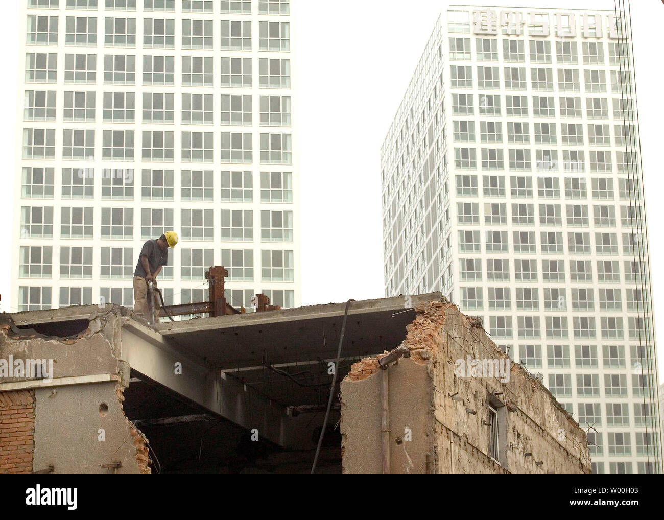 Chinesische Arbeiter ein altes Wohnhaus neben einer riesigen Baustelle in Peking der schnell wachsenden Central Business District, am 29. Oktober 2007 demolieren. China's überkomprimierte Wirtschaft durch eine erstaunliche 11,5 Prozent im dritten Quartal wuchs, etwas verlangsamt, aber Bleiben auf Schiene Deutschland als weltweit drittgrößte innerhalb von Wochen zu überholen, entsprechend den Daten der letzten Woche berichtet. (UPI Foto/Stephen Rasierer) Stockfoto