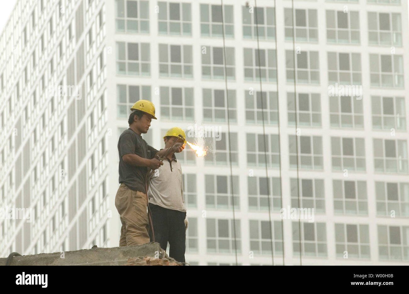 Chinesische Arbeiter ein altes Wohnhaus neben einer riesigen Baustelle in Peking der schnell wachsenden Central Business District, am 29. Oktober 2007 demolieren. China's überkomprimierte Wirtschaft durch eine erstaunliche 11,5 Prozent im dritten Quartal wuchs, etwas verlangsamt, aber Bleiben auf Schiene Deutschland als weltweit drittgrößte innerhalb von Wochen zu überholen, entsprechend den Daten der letzten Woche berichtet. (UPI Foto/Stephen Rasierer) Stockfoto