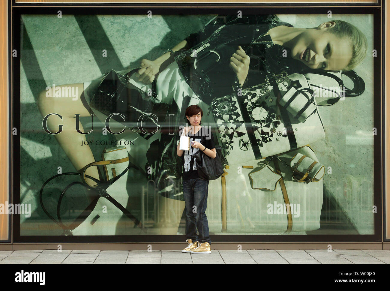 Ein chinesischer Mann wartet auf Freunden vor Gucci Neue flagship Boutique, nur wenige Wochen vor dem Start der Olympischen Spiele 2008 in Peking, in Peking am 23. Juli 2008. (UPI Foto/Stephen Rasierer) Stockfoto