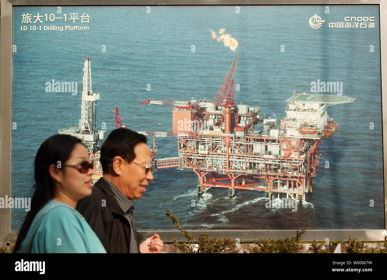 Chinesische vorbei ein Foto einer Öl Bohrinsel außerhalb der Hauptsitz eines der nationalen China's Top 3 Ölgesellschaften in Downtown Beijing April 8, 2009. Die Nachfrage nach Öl in China, den weltweit gro§ten Erdolforderlandern zahlt der zweitgrößte Energie Benutzer, wird durch die hohen Preise gebremst werden als Verbraucher zu steigenden Kosten reagieren, sagte ein Senior Economist bei AustraliaÕs größte Kreditgeber durch Markt wert. (UPI Foto/Stephen Rasierer) Stockfoto