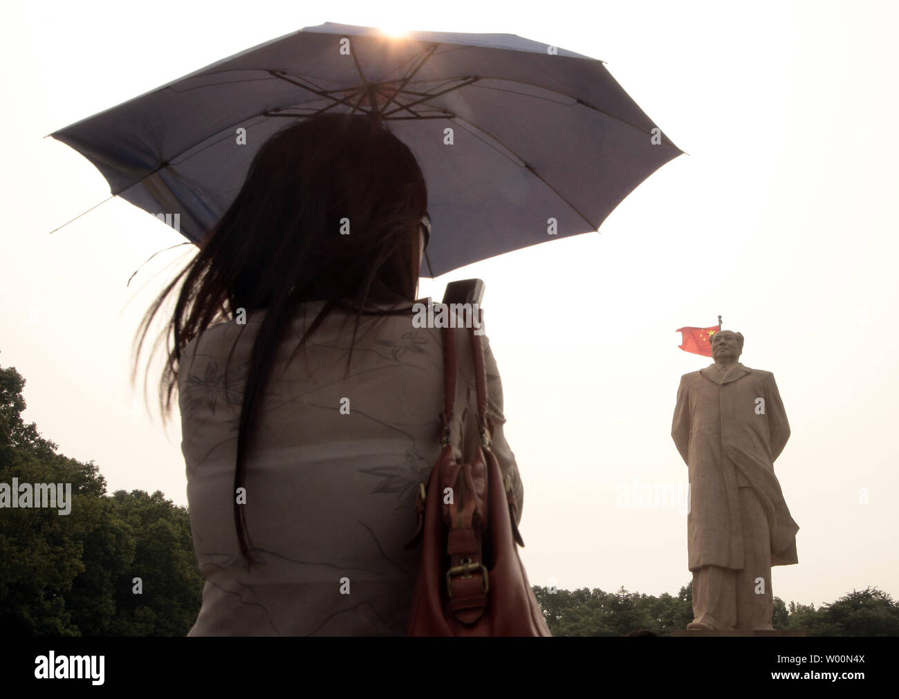 Eine chinesische Frau nimmt einen Snapshot einer gigantischen Statue des ehemaligen Vorsitzenden Mao Zedong vor der Hunan Universität, Changsha, der Hauptstadt der Provinz Hunan, am 12. September 2009. Mao der Kommunistischen Partei Chinas führte zu Sieg gegen die Kuomintang im chinesischen Bürgerkrieg und die PeopleÕs Republik China 1949 gegründet. China wird der 60. Jahrestag am 01. Oktober feiern mit einer großen Militärparade in Peking. UPI/Stephen Rasierer Stockfoto