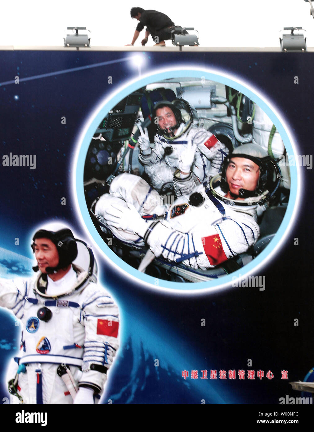 Ein chinesischer Arbeiter installiert leuchtet auf einem riesigen Reklametafeln feiert China's space Program in der Nähe von Pekings Tempo Stadt" am 6. Oktober 2009. China ist aggressiv Beschleunigung der bemannten Raumfahrt durch die Entwicklung einer 17.000 lb. bemannten Militärische Raumfahrt Labor, die bis Ende 2010 geplant. Die Mission wird mit einem Halt in den USA übereinstimmen, die bemannte Raumfahrt mit der Phase-out des Shuttles. UPI/Stephen Rasierer Stockfoto