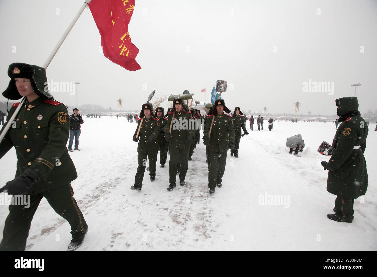 Chinesische Soldaten Gang mit Schaufeln und Besen Schneeverwehungen auf tianmen Square entfernt während eines schweren Schneesturms in Peking am 3. Januar 2010 zu löschen. Ein eiskalt vorne fegte über viel des nördlichen China Sonntag mit schweren Schneestürmen knurrenden Neues Jahr Verkehrs- und Flugreisen und einige der niedrigsten Temperaturen seit Jahrzehnten werden in den nächsten Tagen erwartet. UPI/Stephen Rasierer Stockfoto