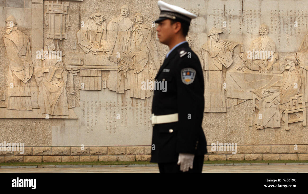 Ein chinesischer Polizist wacht vor dem kulturellen Wand der alten Medizin, das 98 der chinesischen Meister der Traditionellen Chinesischen Medizin (TCM), in der Jiangzhong Medizin Tal in Nanchang, Provinz Jiangxi, 16. Oktober 2010. TCM ist ein 3000 Jahre altes ganzheitliches System der Medizin, die ein tiefes Verständnis für die Gesetze und Muster der Natur und wendet sie auf den menschlichen Körper. UPI/Stephen Rasierer Stockfoto