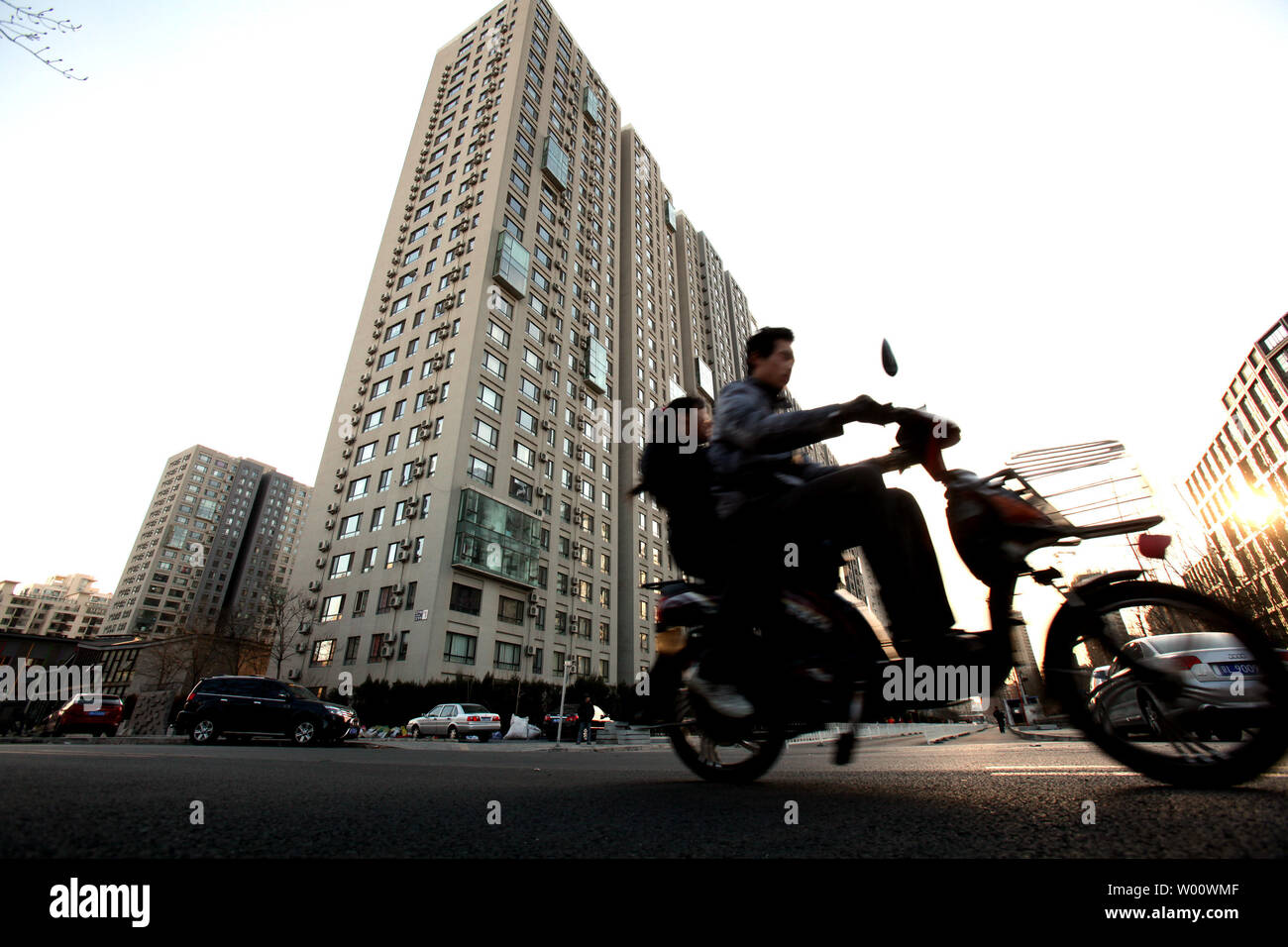 Ein chinesischer Mann fährt mit dem Fahrrad Vergangenheit eine neue Wohnsiedlung in der Innenstadt von Peking, 11. März 2011. Nach dem Überholen die USA als größten Baumarkt in 2010, Chinas Bauwirtschaft mehr als die doppelte Größe von $ 2,5 Bio., 2020. UPI/Stephen Rasierer Stockfoto