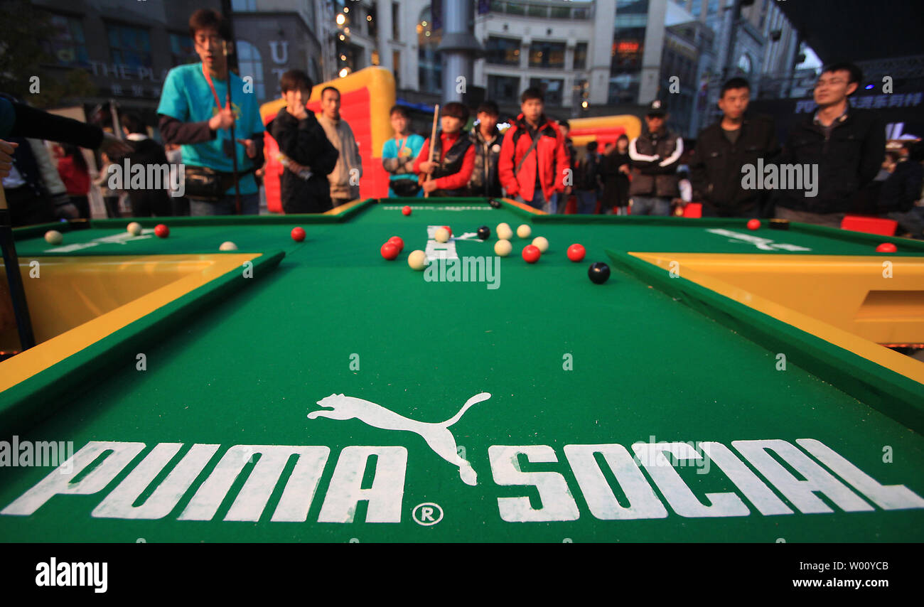 Chinesische spielen eine Form von Snooker für Preise bei einem Konzert von Puma, einem führenden Sport Lifestyle Unternehmen gesponsert, bei einer internationalen Fashion Mall in Peking November 5, 2011. Ausländische Unternehmen, in China Geschäfte zu tun oft lokalen Musikern, Promis und Athleten zu helfen, Ihre Marke zu den größten Verbrauchermarkt der Welt fördern. UPI/Stephen Rasierer Stockfoto