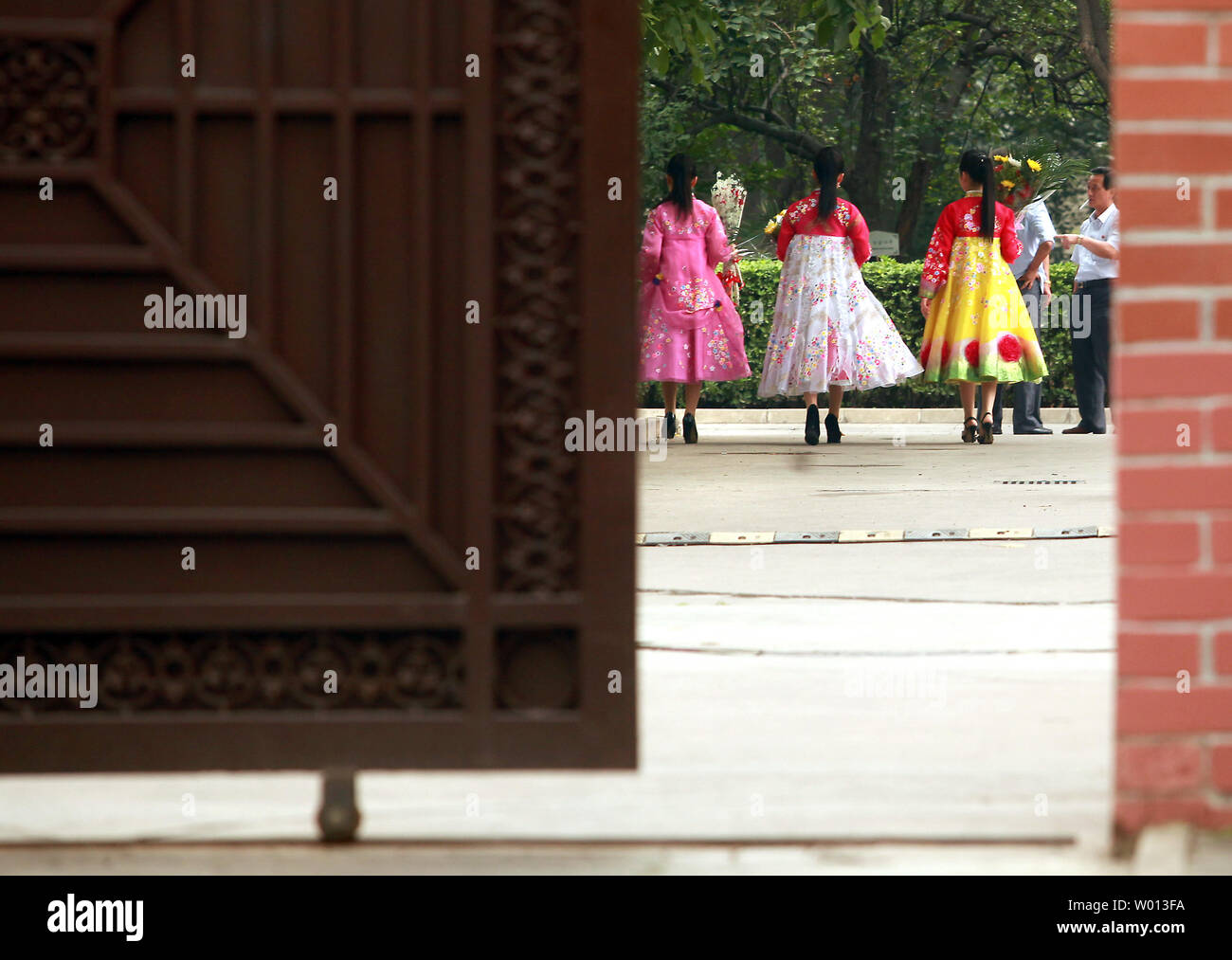 Nordkoreanische Frauen tragen traditionelle Kleider geben Sie die nordkoreanische Botschaft mit Blumen eine Zeremonie zum Gedenken an den 69. Jahrestag der Beendigung des Koreakrieges in Peking am 26. Juli 2013 zu besuchen. UPI/Stephen Rasierer Stockfoto