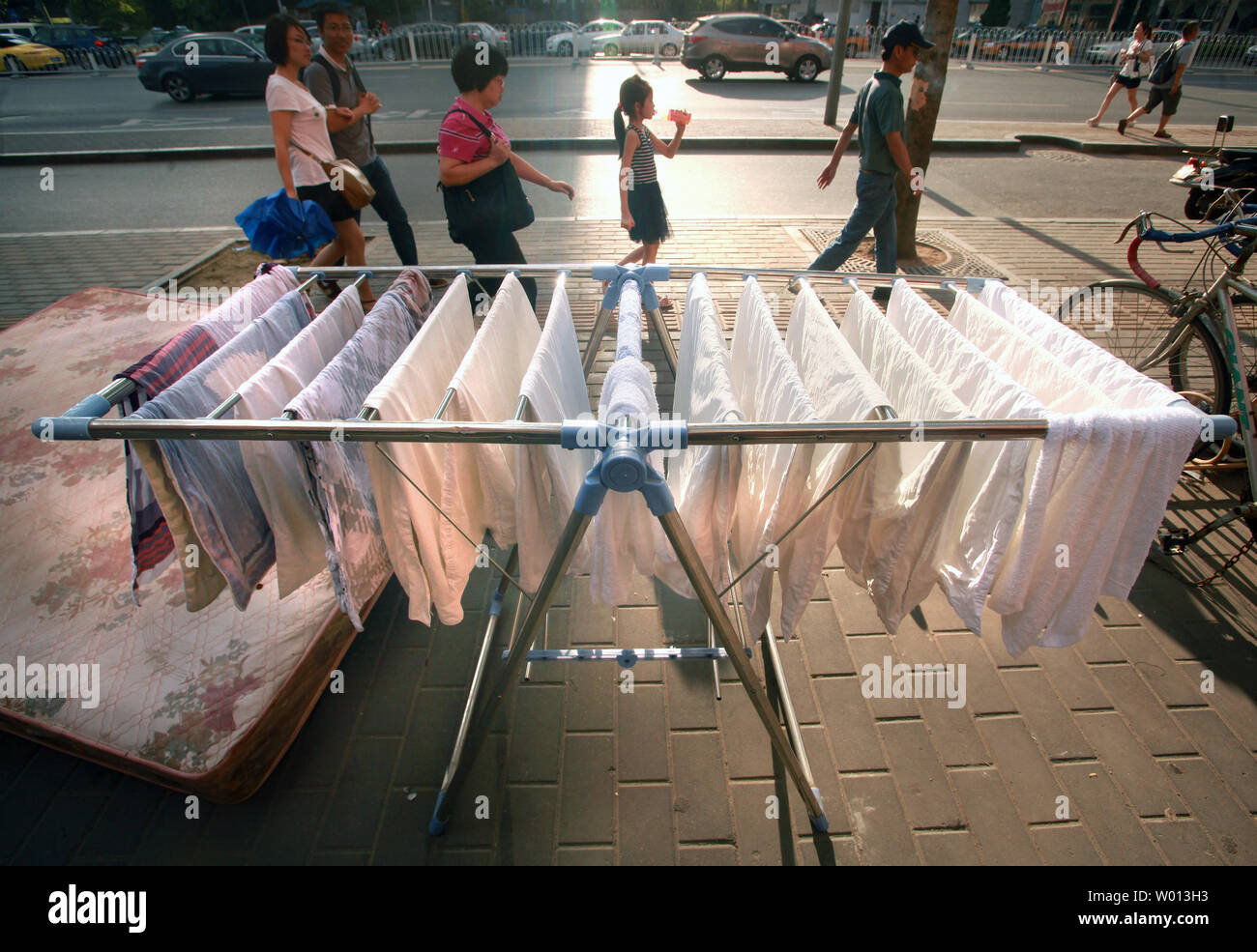 Chinesische vorbei Handtücher hingen heraus auf einem Bürgersteig in der Innenstadt von Peking am 18. August 2013 zu trocknen. Eine neue landesweite Umfrage unterstreicht die breite Kluft zwischen China's haben und Habenichtse, und schlägt vor, dass die Wirtschaft die aktuelle Verlangsamung mit breiten Arbeitslosigkeit bereits hohe eingegeben. UPI/Stephen Rasierer Stockfoto