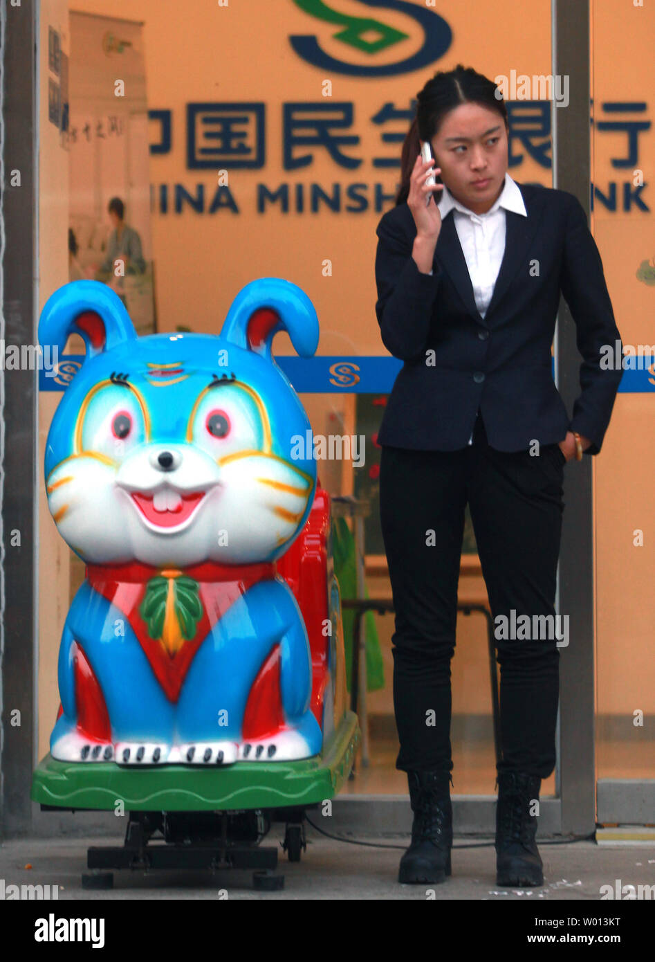 Eine Chinesische bank Gespräche über das Telefon außerhalb Ihrer Bank in der Innenstadt von Peking am 8. November 2013. Chinas Bankenaufsicht verpfändet härter arbeiten, um die Risiken einer möglichen Aufstieg in nicht zu Kopf - Durchführung des Persönlichen und gewerbliche Kredite. UPI/Stephen Rasierer Stockfoto