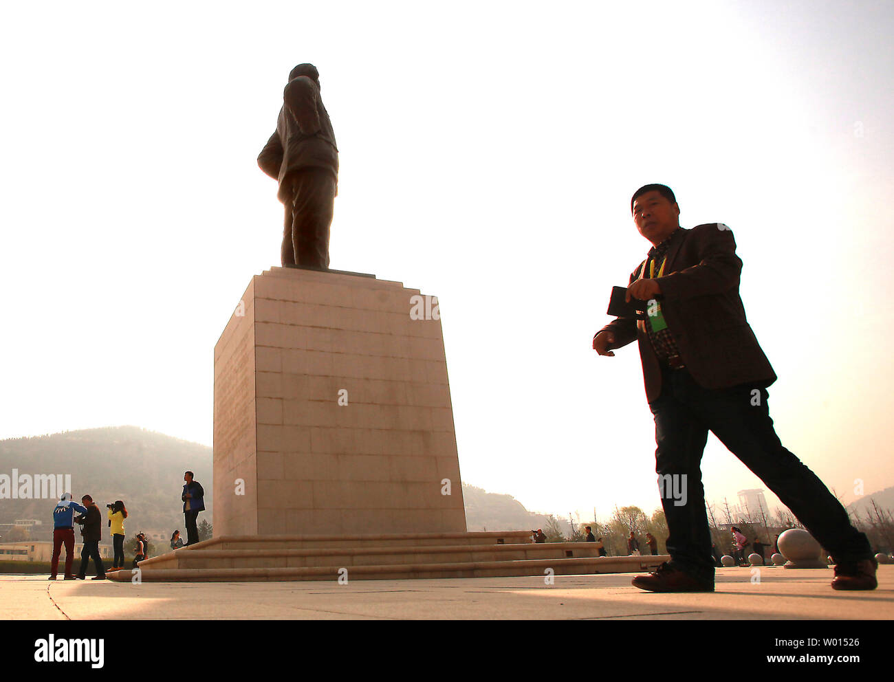 Chinesische vorbei durch eine große Statue von Chinas ehemaligen Steuermann Mao Zedong bei der Ankunft im Revolutionären Memorial Hall, präsentiert die Ereignisse, die zu der Entstehung der Volksrepublik China führte, in Yan'an, Provinz Shaanxi, am 6. April 2014. Yan'an war in der Nähe der Endpunkt der Langen Marsch, und wurde zum Zentrum der Chinesischen Kommunistischen Revolution führte meine Mao von 1936 bis 1948. Die chinesischen Kommunisten feiern die Stadt als Geburtsstätte des modernen China und der Kult von Mao. UPI/Stephen Rasierer Stockfoto