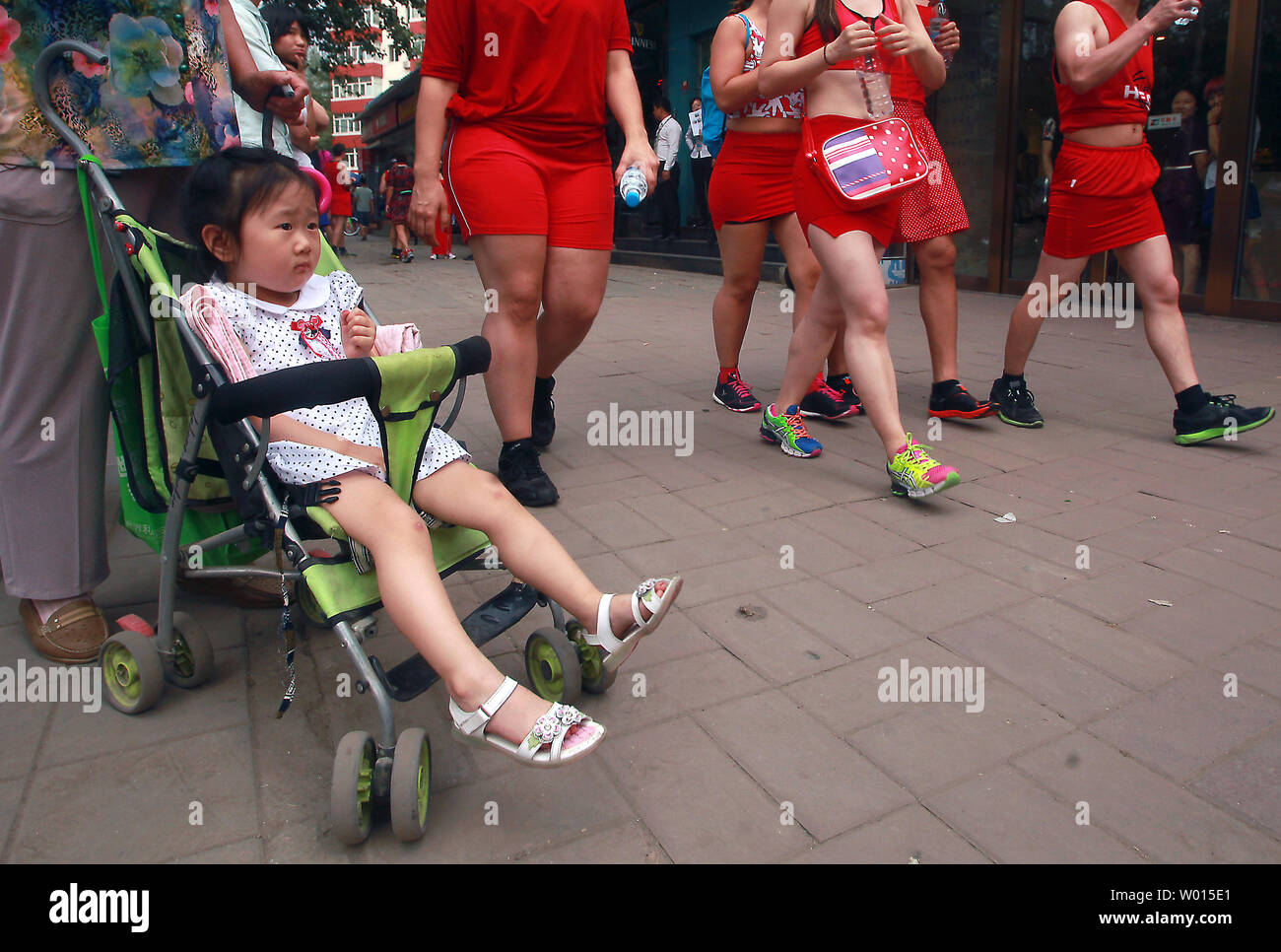 Ausländer und Chinesen, sowohl Männer als auch Frauen, rote Kleider tragen, während sie durch die Straßen von Peking laufen für die jährliche Rotes Kleid laufen für den guten Zweck am 8. Juni 2014. Die Veranstaltung Erlös Spenden für Orbis, einem globalen NRO Zugang zu kostenlosen, Qualität ländlichen Eye Care für die mehr als acht Millionen blinde Menschen in China zu verbessern. UPI/Stephen Rasierer Stockfoto